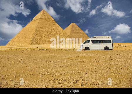 Une camionnette blanche vide transporte les touristes devant les pyramides de Gizeh au Caire, Egypte, Afrique Banque D'Images