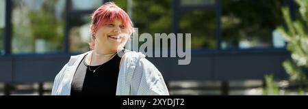 Une femme de grande taille aux cheveux roses sourit brillamment alors qu'elle marche à l'extérieur. Banque D'Images