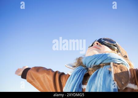 Enfant heureux jouant avec un avion jouet sur fond de ciel bleu. Copiez l'espace pour votre texte Banque D'Images