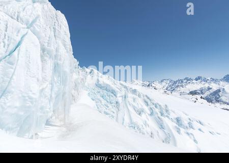 Un grand glacier enneigé, haut dans les montagnes, sur fond de montagnes du Caucase et ciel bleu Banque D'Images