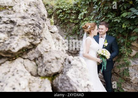 Portrait en gros plan d'un couple adorable de jeunes mariés sur fond de greens d'été. Le concept de la vie heureuse de Hipster dans le mariage Banque D'Images