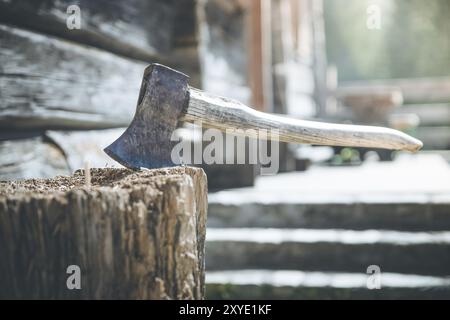 Vieille ax attaché à un tronc d'arbre, alpine hut Banque D'Images