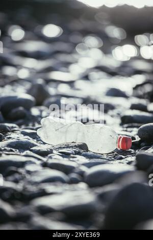 Bouteille de plastique est allongé sur la plage de galets, la pollution de l'environnement Banque D'Images