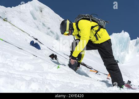 Un skieur professionnel debout sur un glacier se prépare à un saut tout en installant son équipement de ski. Le concept d'entraînement de qualité pour le sport Banque D'Images