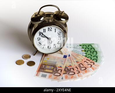 Billets en euros avec une vieille horloge mécanique, le temps c'est de l'argent Banque D'Images