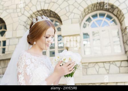 Portrait d'une belle mariée dans une robe blanche et un bouquet de fleurs dans ses mains. Le concept de beauté de mariage dans l'éco-style Banque D'Images