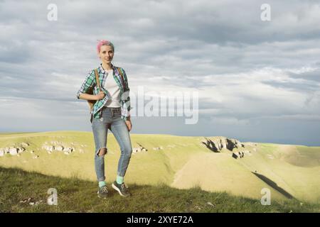 Une étudiante à l'extérieur dans la campagne sur un voyage d'été en été souriant. Étudiante caucasienne de collège ou d'université en randonnée Banque D'Images