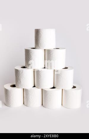 Rouleaux de papier toilette disposés comme une pyramide sur du papier blanc Banque D'Images