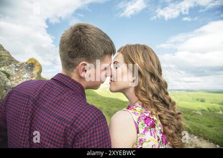 Un jeune couple marié tend la main pour un baiser sur le fond d'une belle nature. Concept d'une jeune famille heureuse Banque D'Images