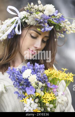 Gros plan portrait d'une fille avec une couronne sur la tête contre une cascade dans la nature Banque D'Images