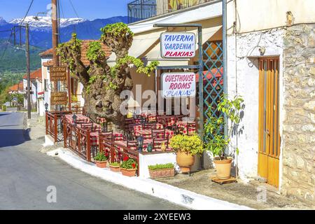 Météores, Grèce, 27 avril 2015 : tables et chaises à la taverne grecque traditionnelle entourées de fleurs dans le village de Kastraki, en Europe Banque D'Images