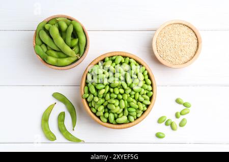 Soja edamame frais, gousses et graines sur table en bois blanc, pose à plat Banque D'Images