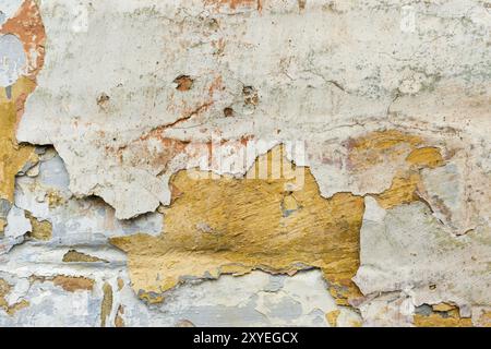 Close-up background multi-couche de peinture écaillée sur le mur. Le mélange de différentes couleurs de peintures dans l'fendues couches sur la surface. Grunge Banque D'Images
