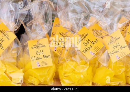 Traditionnel Ould Lammas Fair Yellow Man, sacs de délicieux bonbons alléchants sur le marché étal. Ballycastle, Royaume-Uni - 26 août 2024. Banque D'Images