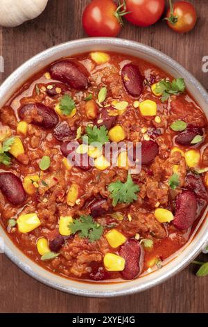 Un passage photo gros plan de chili con carne, un plat traditionnel mexicain avec les haricots rouges, feuilles de coriandre, la viande hachée et piments Banque D'Images