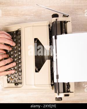 L'homme écrit une lettre sur une machine à écrire vintage. Vue de dessus Banque D'Images