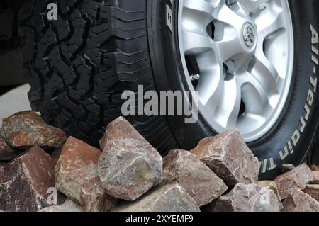 Pneu de roue de véhicule tout-terrain sur rochers gros plan. Concept de conduite tout-terrain Banque D'Images