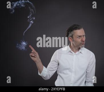 L'homme d'affaires avec un grand point d'interrogation de la vapeur sur un fond sombre Banque D'Images