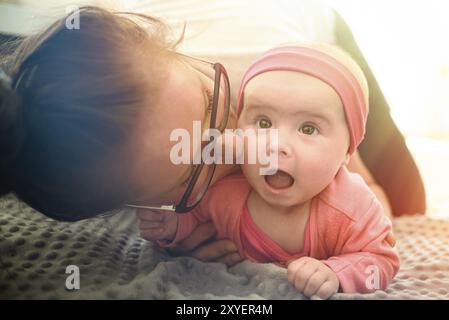 Portrait of cute 5 semaine baby girl avec la mère sur le plancher dans brigkt salon. Concept de soins pour bébés Banque D'Images