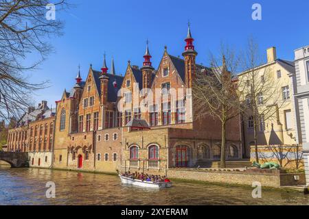 Bruges, Belgique, 10 avril 2016 : paysage urbain pittoresque avec des maisons médiévales, bateau avec des touristes et canal à Bruges, Europe Banque D'Images