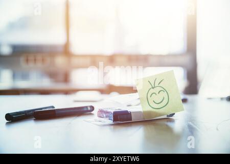 Smiley illustration à la place de travail, atelier. Stylos et fenêtre dans l'arrière-plan flou Banque D'Images