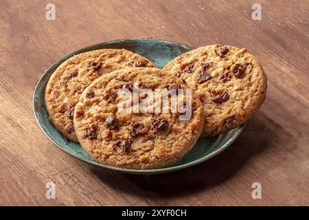 Une photo gros plan de cookies aux pépites de chocolat sur un fond de bois rustique foncé Banque D'Images