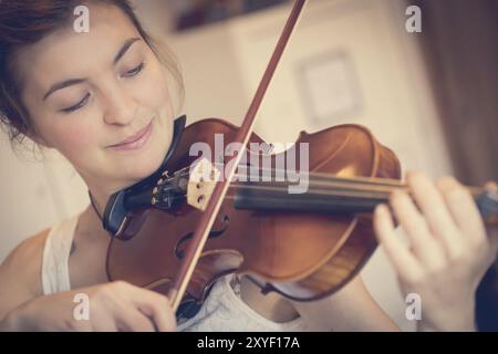 Jolie jeune fille pratique sur son violon, musique acoustique Banque D'Images