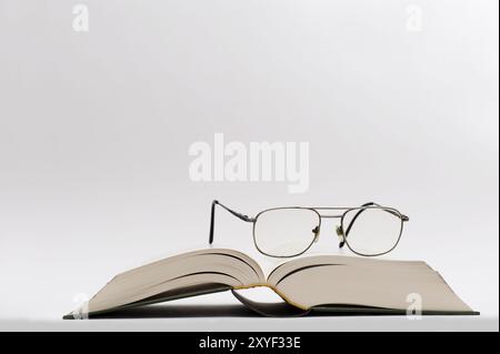 Lunettes couchées sur un livre ouvert Banque D'Images