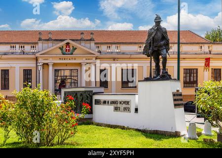 Asti, Italie - 20 août 2024 : Monument dédié aux Alpini militaires devant l'entrée du marché couvert historique de la place de la liberté Banque D'Images