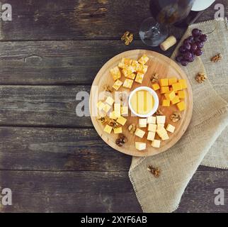 Raisin, ensemble de différents types de fromages avec un verre de vin rouge sur la table en bois Banque D'Images