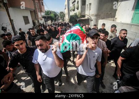 Naplouse, Palestine. 29 août 2024. (NOTE DE LA RÉDACTION : image représente la mort) les personnes en deuil marchent avec l'un des corps de quatre Palestiniens qui ont été tués dans une opération militaire israélienne lors de ses funérailles dans le camp de réfugiés palestiniens de Fara près de Tubas dans le nord de la Cisjordanie occupée. Le 28 août, Israël a lancé une opération à grande échelle en Cisjordanie occupée où ils ont tué des combattants palestiniens, car cela fait presque 11 mois à Gaza, la guerre ne montre aucun signe de ralentissement. Crédit : SOPA images Limited/Alamy Live News Banque D'Images