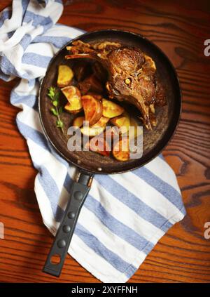 La viande de chèvre braisé avec sauce et pommes de terre rôties à la poêle. Vue d'en haut Banque D'Images