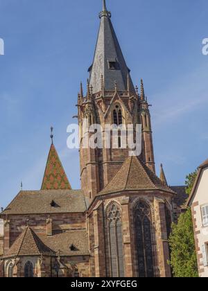 Vue détaillée d'une tour d'église gothique et de la façade historique face à un ciel bleu, Weissenburg, Alsace, France, Europe Banque D'Images