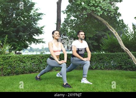 Jeune couple exercising happpy et étirer les muscles avant l'activité sportive Banque D'Images