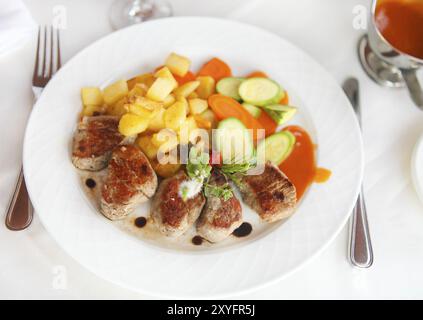 Pavé de boeuf grillé avec des légumes sur plaque blanche Banque D'Images