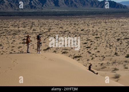 Un gouffre de trois personnes au sommet d'une colline dans le désert. Paysage désertique. Gran Desierto de Altar, Sonora, Mexique. Banque D'Images