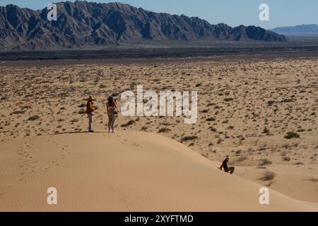 Un gouffre de trois personnes au sommet d'une colline dans le désert. Paysage désertique. Gran Desierto de Altar, Sonora, Mexique. Banque D'Images