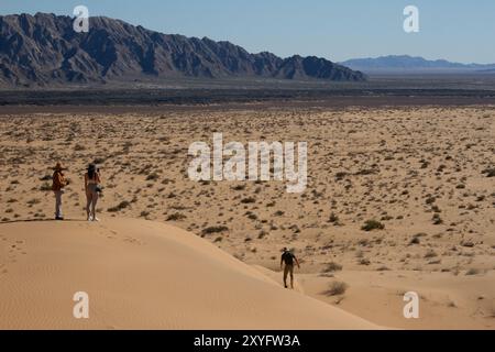 Un gouffre de trois personnes au sommet d'une colline dans le désert. Paysage désertique. Gran Desierto de Altar, Sonora, Mexique. Banque D'Images