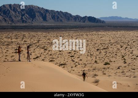 Un gouffre de trois personnes au sommet d'une colline dans le désert. Paysage désertique. Gran Desierto de Altar, Sonora, Mexique. Banque D'Images