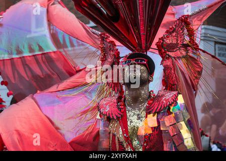 Showtime au Carnaval annuel de Notting Hill alors que les artistes soigneusement habillés de la Adult's Parade progressent lentement dans l'ouest de Londres Banque D'Images