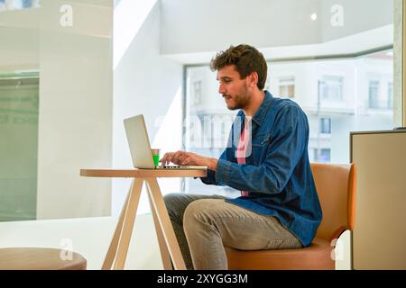 la jeune étudiante profite de sa pause café pour utiliser son ordinateur portable Banque D'Images