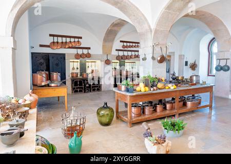 SINTRA, Portugal — la grande cuisine du Palais de Pena, présentant une impressionnante gamme de ustensiles de cuisine en cuivre et des installations de cuisine du XIXe siècle. Cet espace bien préservé offre aux visiteurs un aperçu des opérations culinaires d'une maison royale, avec son immense foyer, ses tuiles ornées et ses ustensiles étincelants reflétant le caractère opulent du palais et les technologies de cuisson avancées de l'époque. Banque D'Images