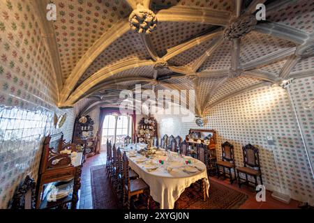 SINTRA, Portugal — la salle à manger du Palais de Pena, anciennement le réfectoire des moines Hiéronymites, convertie par le roi Ferdinand II en salle à manger privée de la famille royale portugaise. La chambre présente des voûtes en côtes manuélines datant du XVIe siècle et est bordée de tuiles du XIXe siècle réalisées par Fábrica Roseira. Le mobilier en chêne, commandé par le roi Ferdinand II en 1866 à Casa Barbosa e Costa, ajoute à l'ambiance historique et royale de l'espace. Banque D'Images