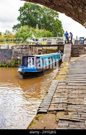 Bateau étroit quittant les écluses jumelles à double escalier sur le canal Shropshire Union à Bunbury Cheshire Banque D'Images