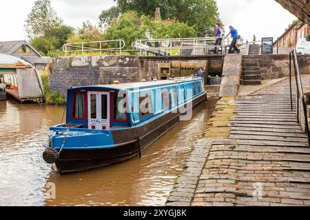 Bateau étroit quittant les écluses jumelles à double escalier sur le canal Shropshire Union à Bunbury Cheshire Banque D'Images