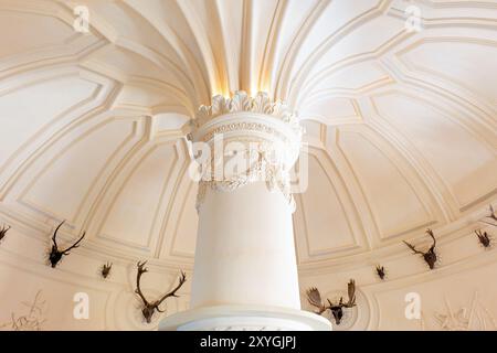 SINTRA, Portugal — la salle des cerfs du Palais de Pena, un espace unique qui reflète les traditions royales de chasse de la cour portugaise du XIXe siècle. Située à Sintra, cette chambre est ornée de trophées de chasse et présente un décor romantiste mêlant des éléments médiévaux et gothiques. Le Palais de Pena, classé au patrimoine mondial de l’UNESCO, est l’un des monuments les plus emblématiques du Portugal, connu pour son architecture éclectique et ses intérieurs richement décorés. Banque D'Images