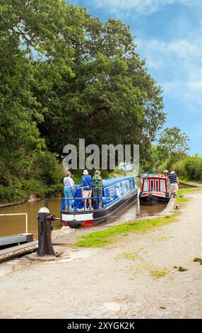 Bateau étroit quittant les écluses jumelles à double escalier sur le canal Shropshire Union à Bunbury Cheshire Banque D'Images