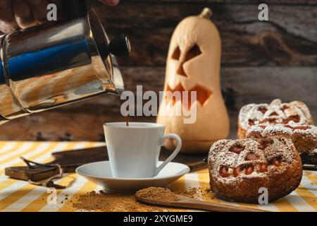 Café méconnaissable dans une tasse, au premier plan bonbon en forme de citrouille, en arrière-plan une citrouille d'Halloween, style Halloween, jour des morts. Banque D'Images