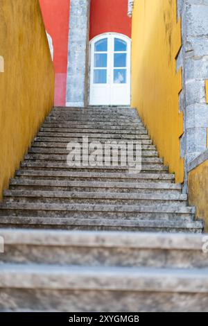 SINTRA, Portugal — Un escalier en pierre au Palais de Pena, un monument architectural important à Sintra, Portugal. Le palais est réputé pour son architecture romantiste et est classé au patrimoine mondial de l'UNESCO. L'escalier est l'un des nombreux qui mènent les visiteurs à travers les vastes jardins du palais, qui mélangent des influences architecturales gothiques, mauresques et Renaissance. Banque D'Images