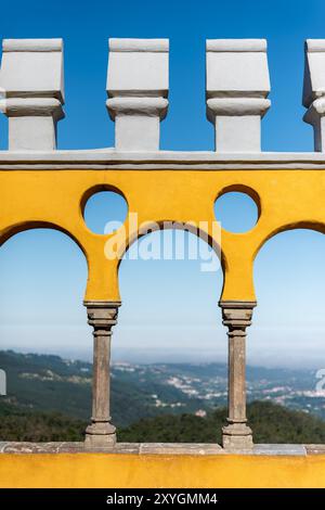 SINTRA, Portugal — la cour des Arches au Palais de Pena, un exemple étonnant de l'architecture romantiste situé à Sintra. La cour est caractérisée par une série d'arches de style néo-mauresque, offrant une vue panoramique sur les paysages environnants. Le Palais de Pena, classé au patrimoine mondial de l’UNESCO, est l’un des monuments les plus emblématiques du Portugal, réputé pour ses couleurs vives et son style architectural éclectique. Banque D'Images